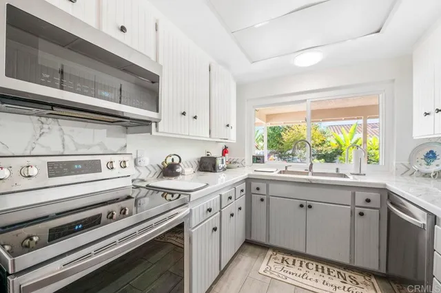 a kitchen with a stove a sink and a window