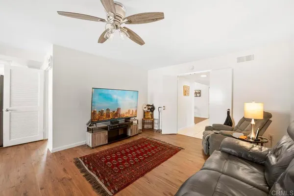 a living room with furniture and a wooden floor