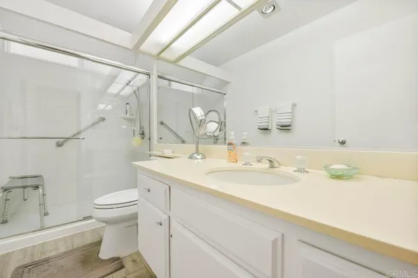 a bathroom with a sink a toilet and shower