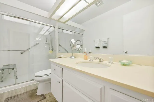 a bathroom with a sink a toilet and shower