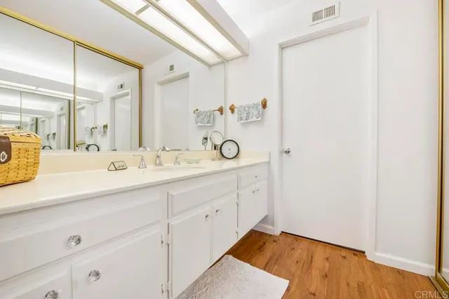 a spacious bathroom with a granite countertop sink a mirror and shower view