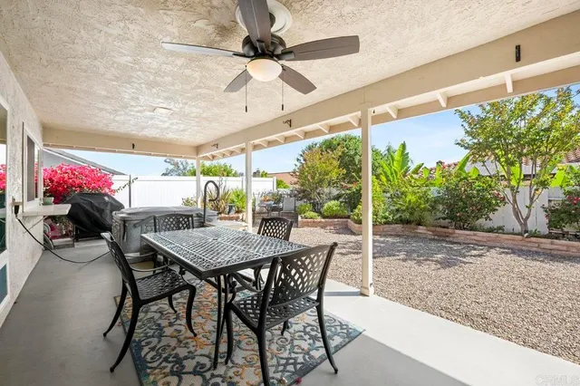 a view of a patio with a table and chairs and a floor to ceiling window
