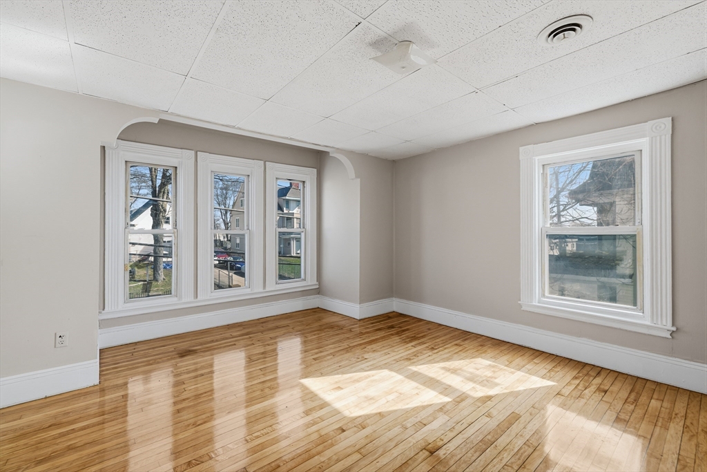 28 Prospect Street Brockton, MA 02301 - Photo 11 of 22 a view of an empty room with a window and wooden floor
