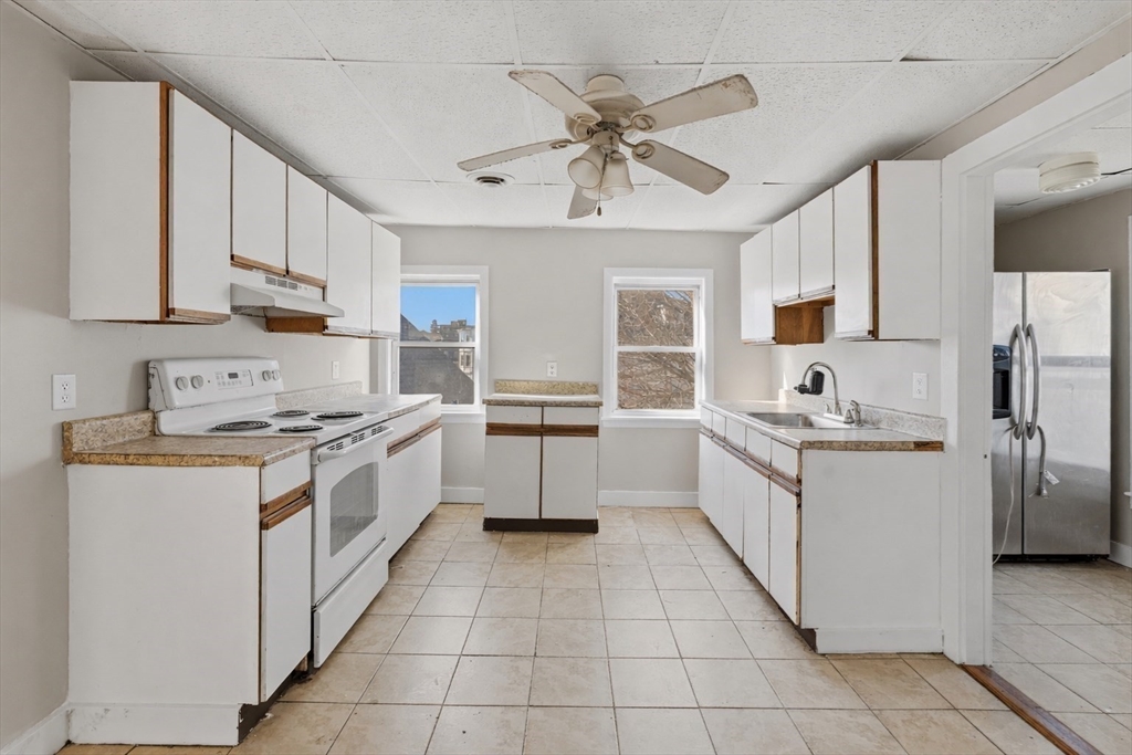 28 Prospect Street Brockton, MA 02301 - Photo 7 of 22 a kitchen with a stove sink and cabinets