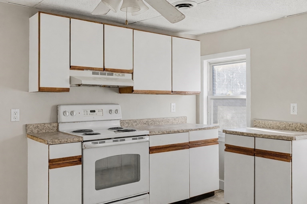 28 Prospect Street Brockton, MA 02301 - Photo 8 of 22 a kitchen with granite countertop white cabinets and white appliances