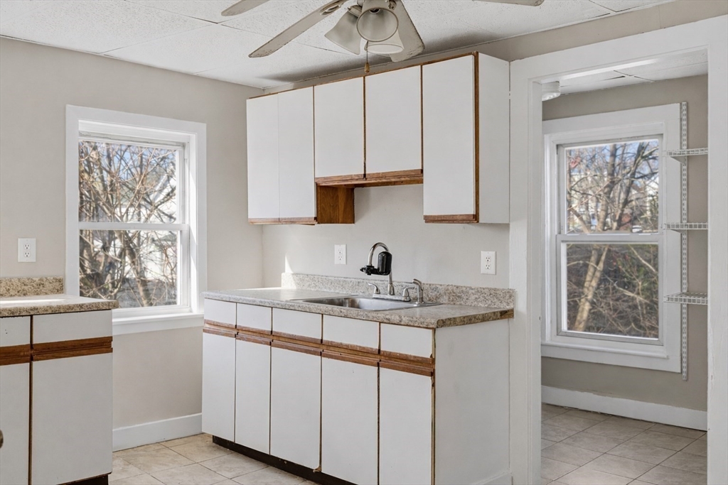 28 Prospect Street Brockton, MA 02301 - Photo 9 of 22 a kitchen with stainless steel appliances granite countertop a sink window and cabinets