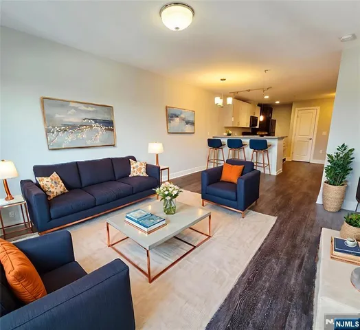 a living room with furniture a wooden floor and a sink