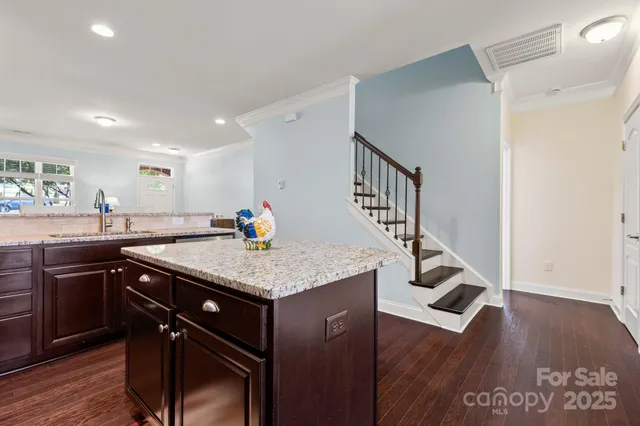 a kitchen with a sink cabinets and wooden floor