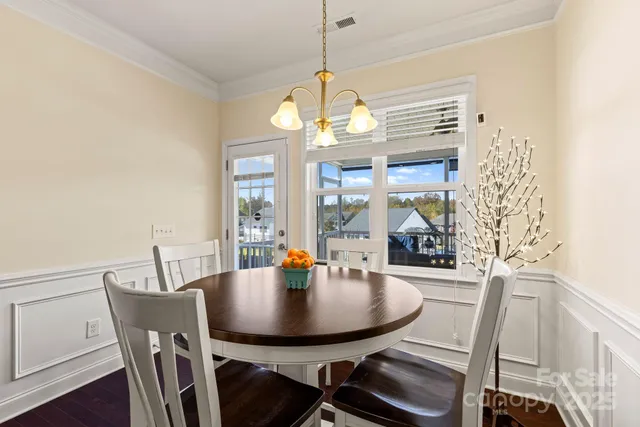 a dining room with furniture a chandelier and wooden floor