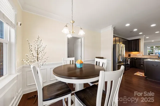 a kitchen with sink refrigerator dining table and chairs