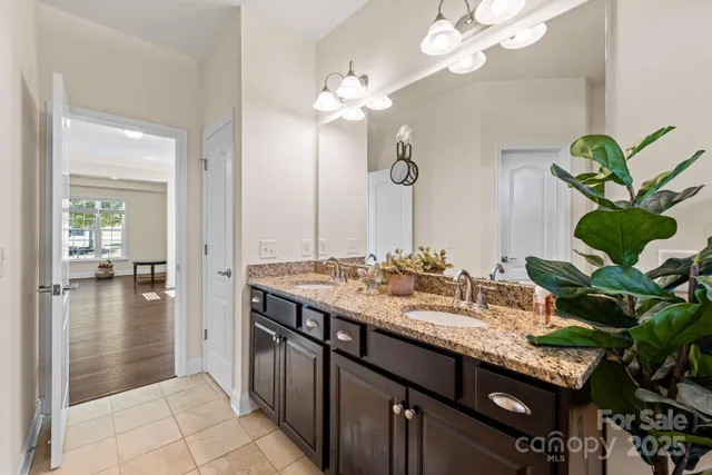 a bathroom with a granite countertop sink a large mirror and a shower