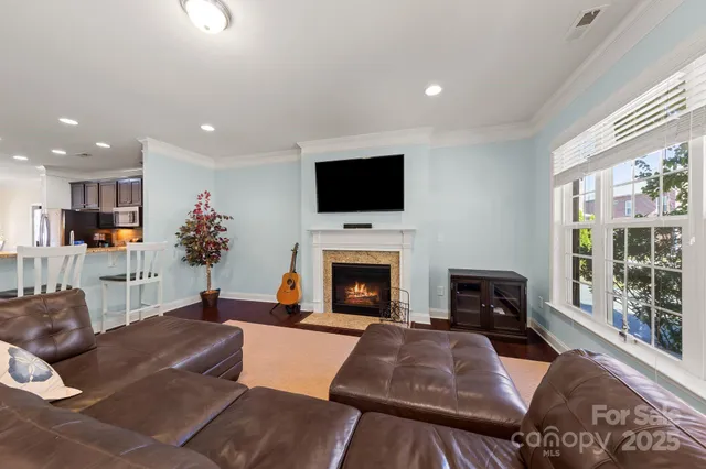 a living room with furniture a fireplace and a flat screen tv