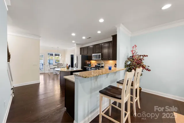 a view of kitchen with kitchen island a stove and a wooden floors