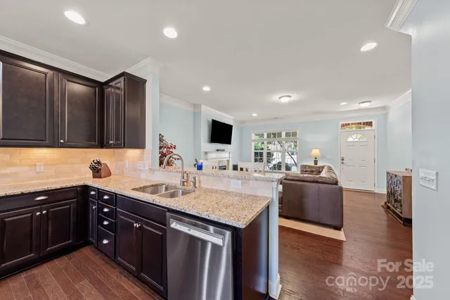 a kitchen with stainless steel appliances granite countertop a sink stove and wooden floor