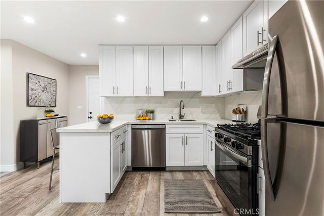 a kitchen with a sink stainless steel appliances and cabinets