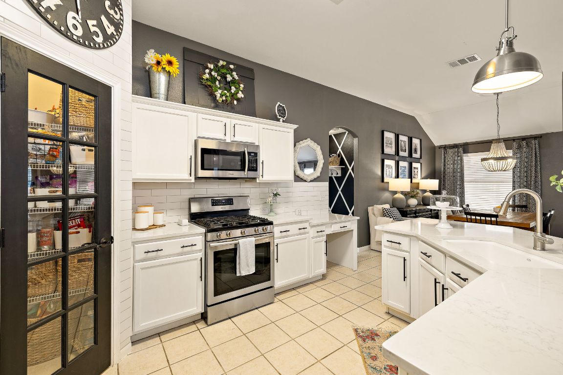 131 Chandler Pointe Loop Round Rock, TX 78665 - Photo 13 of 31 a kitchen with white cabinets stainless steel appliances and a counter top space