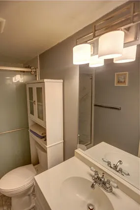 a bathroom with a sink a toilet and shower