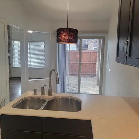 a kitchen with a sink a counter top space and cabinets