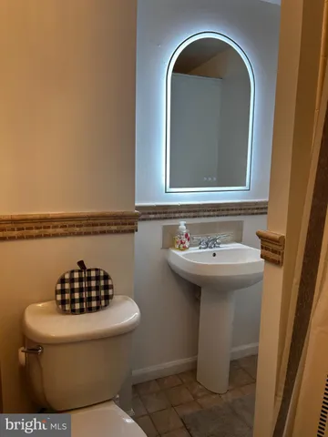 a bathroom with a sink and mirror with toilet
