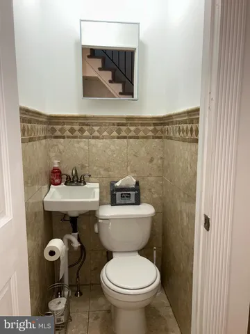 a bathroom with a toilet a sink and mirror