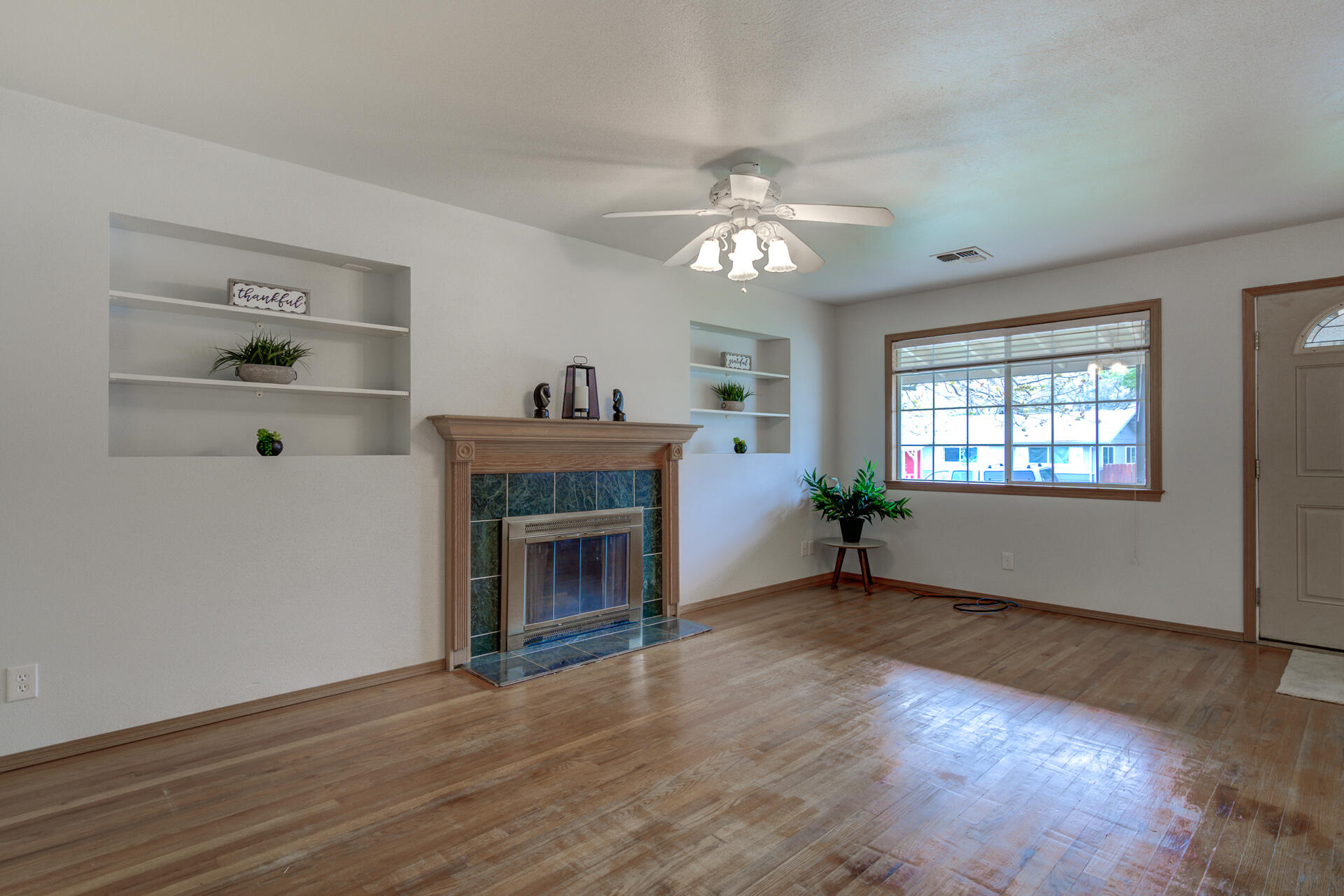 1208 Riviera Drive Redding, CA 96001 - Photo 4 of 39 an empty room with wooden floor fireplace and windows