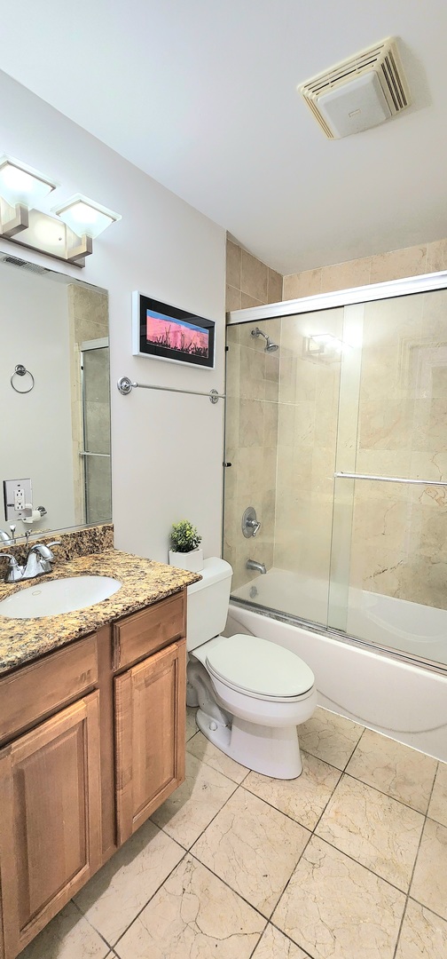 4002 South Western Avenue, Unit 4 Chicago, IL 60609 - Photo 15 of 31 a bathroom with a granite countertop sink a toilet a mirror and shower