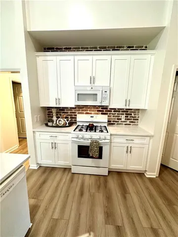 a white kitchen with wooden floor