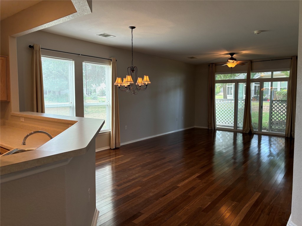 106 Bowie Circle Georgetown, TX 78633 - Photo 14 of 33 a view of a room with wooden floor staircase and a kitchen