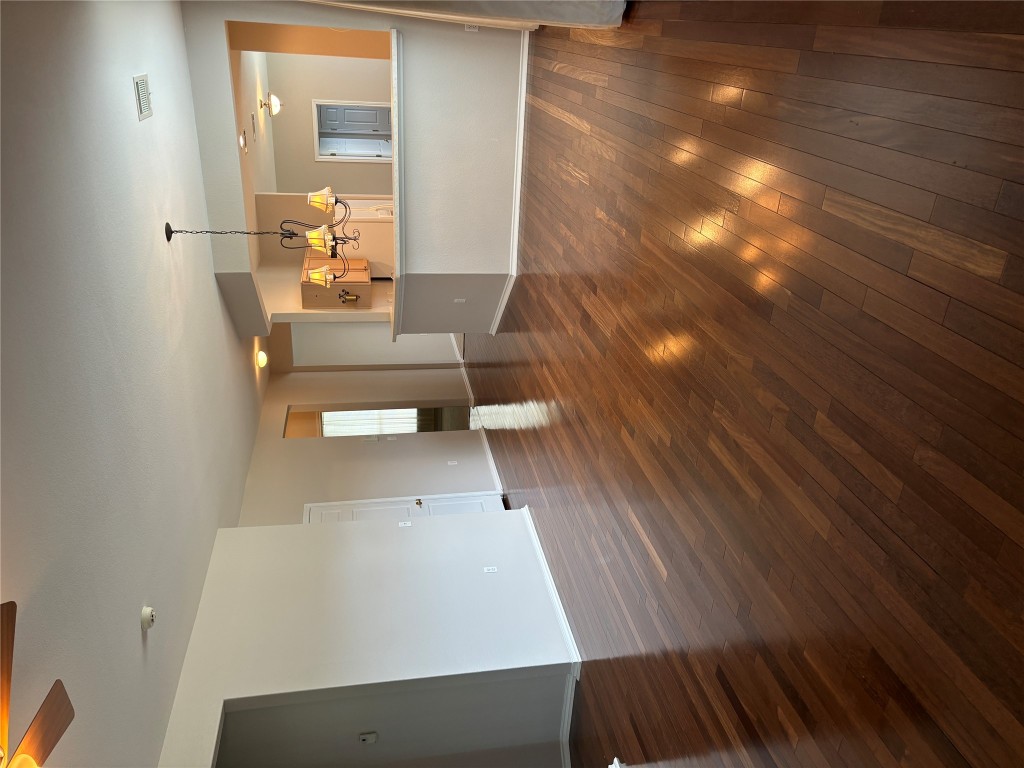 106 Bowie Circle Georgetown, TX 78633 - Photo 2 of 33 an empty room with wooden floor kitchen view and a fireplace