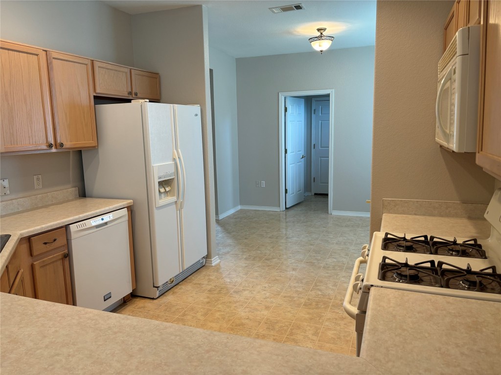 106 Bowie Circle Georgetown, TX 78633 - Photo 7 of 33 a kitchen with a refrigerator and a stove