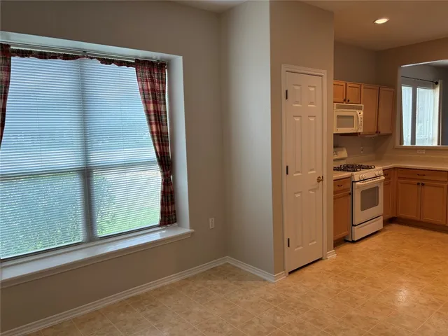 a view of a kitchen with a sink and dishwasher a refrigerator with wooden floor