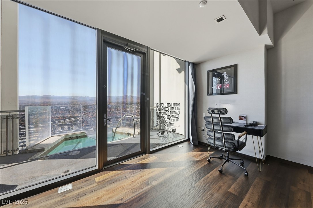 4381 West Flamingo Road, Unit 58301 Las Vegas, NV 89103 - Photo 14 of 32 Home office with expansive windows and dark wood-style floors