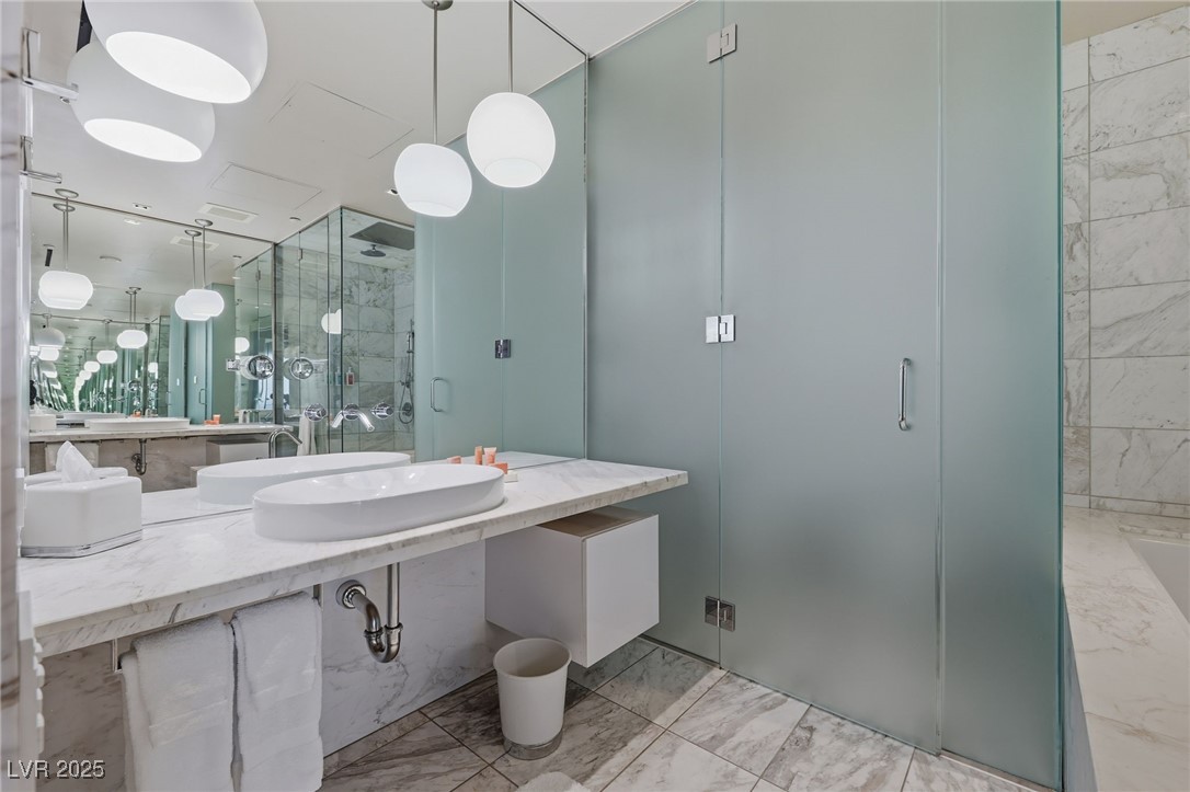 4381 West Flamingo Road, Unit 58301 Las Vegas, NV 89103 - Photo 23 of 32 Bathroom with vanity, light marble finish flooring, and a marble finish shower