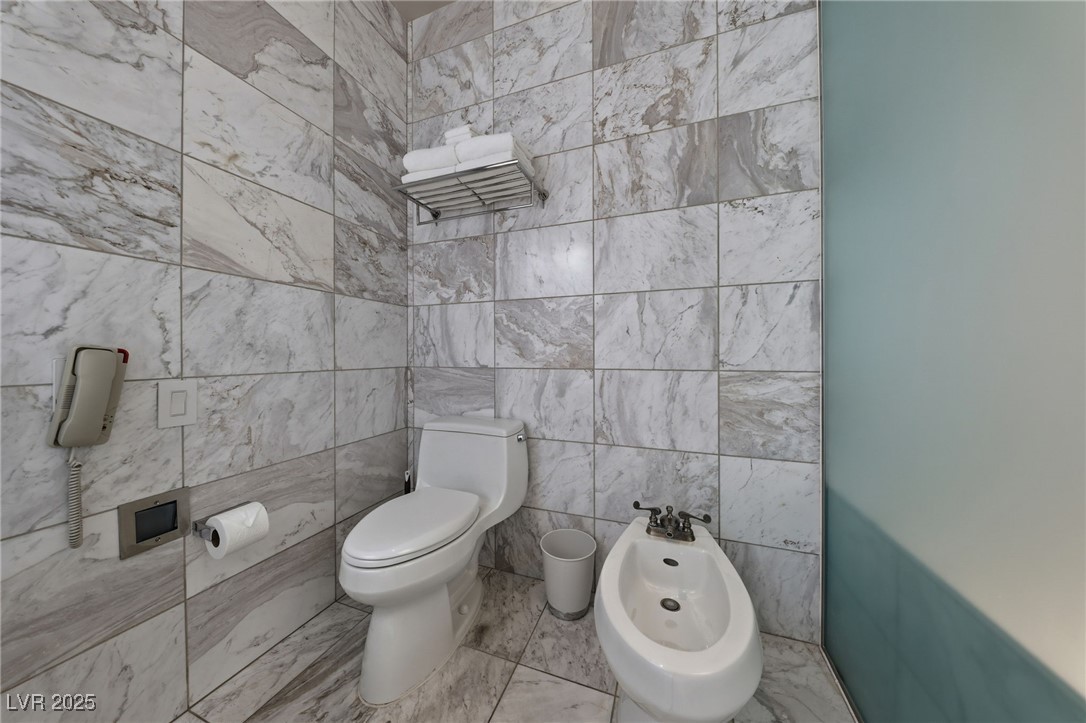 4381 West Flamingo Road, Unit 58301 Las Vegas, NV 89103 - Photo 24 of 32 Half bath with a bidet and tile walls