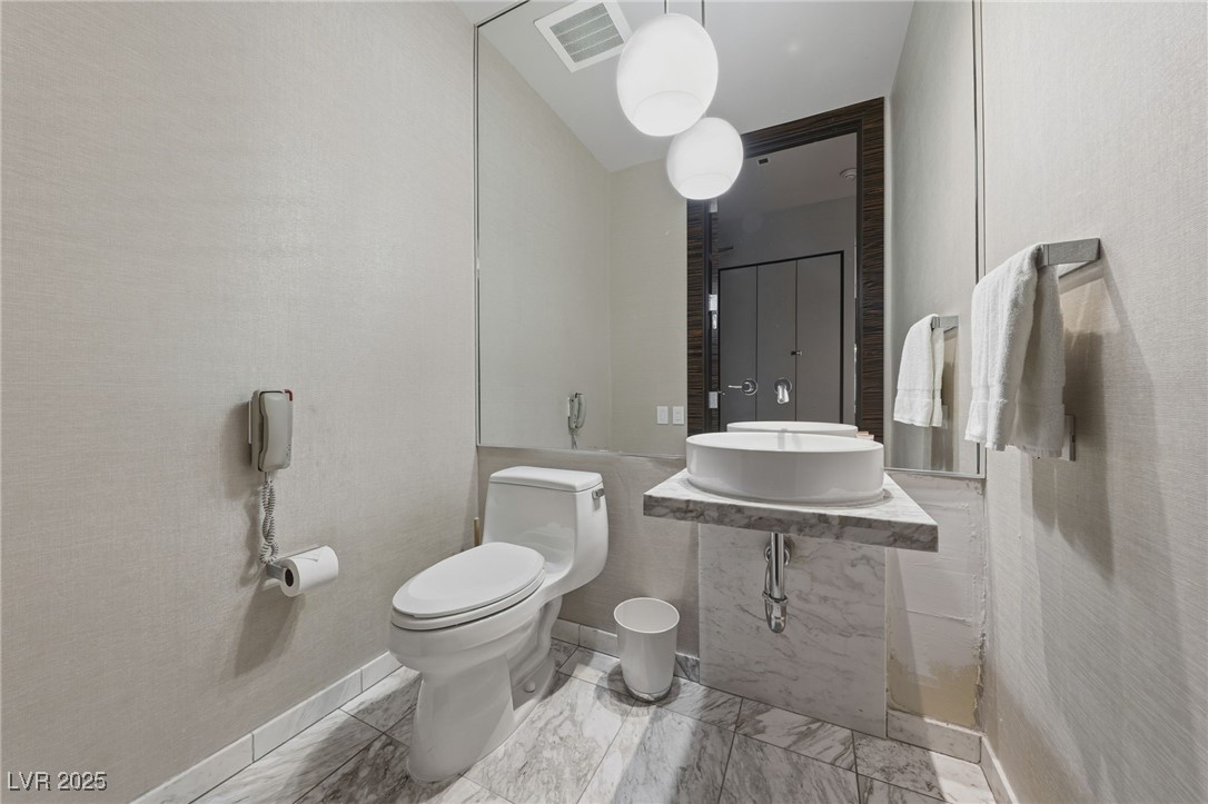 4381 West Flamingo Road, Unit 58301 Las Vegas, NV 89103 - Photo 25 of 32 Half bathroom with toilet and vanity