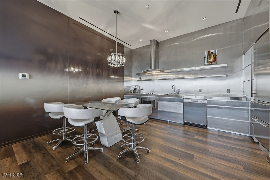 4381 West Flamingo Road, Unit 58301 Las Vegas, NV 89103 - Photo 9 of 32 Kitchen featuring stainless steel counters, modern cabinets, decorative light fixtures, built in appliances, and ventilation hood