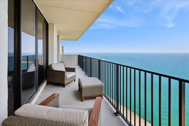 a balcony with couch and a potted plant