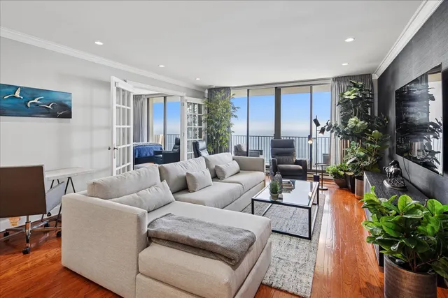 a living room with furniture a flat screen tv and a potted plant