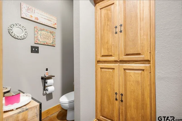 a bathroom with a granite countertop toilet and a sink