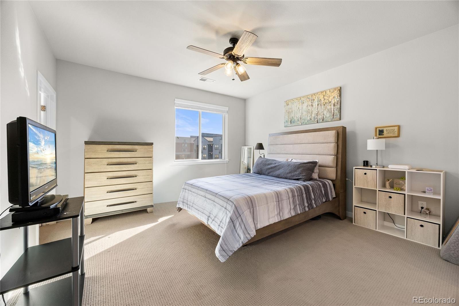 9291 Twenty Mile Road, Unit 303 Parker, CO 80134 - Photo 14 of 28 a bedroom with a bed and a flat screen tv