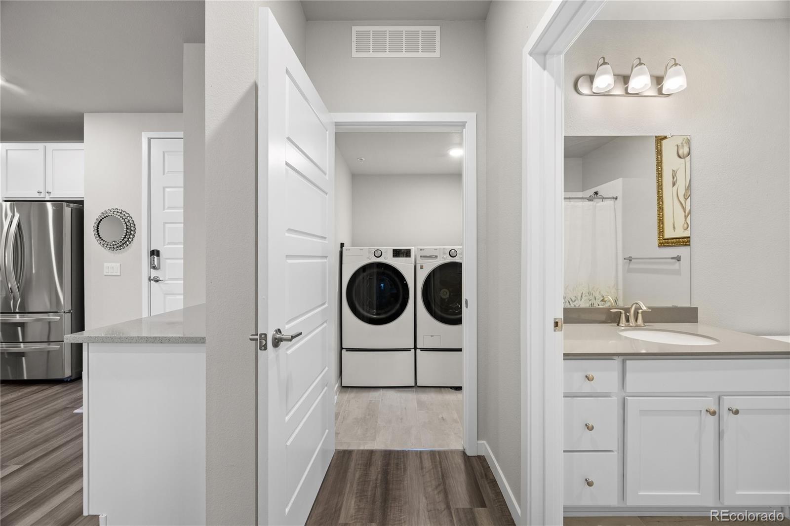 9291 Twenty Mile Road, Unit 303 Parker, CO 80134 - Photo 19 of 28 a bathroom with a sink a washer and dryer