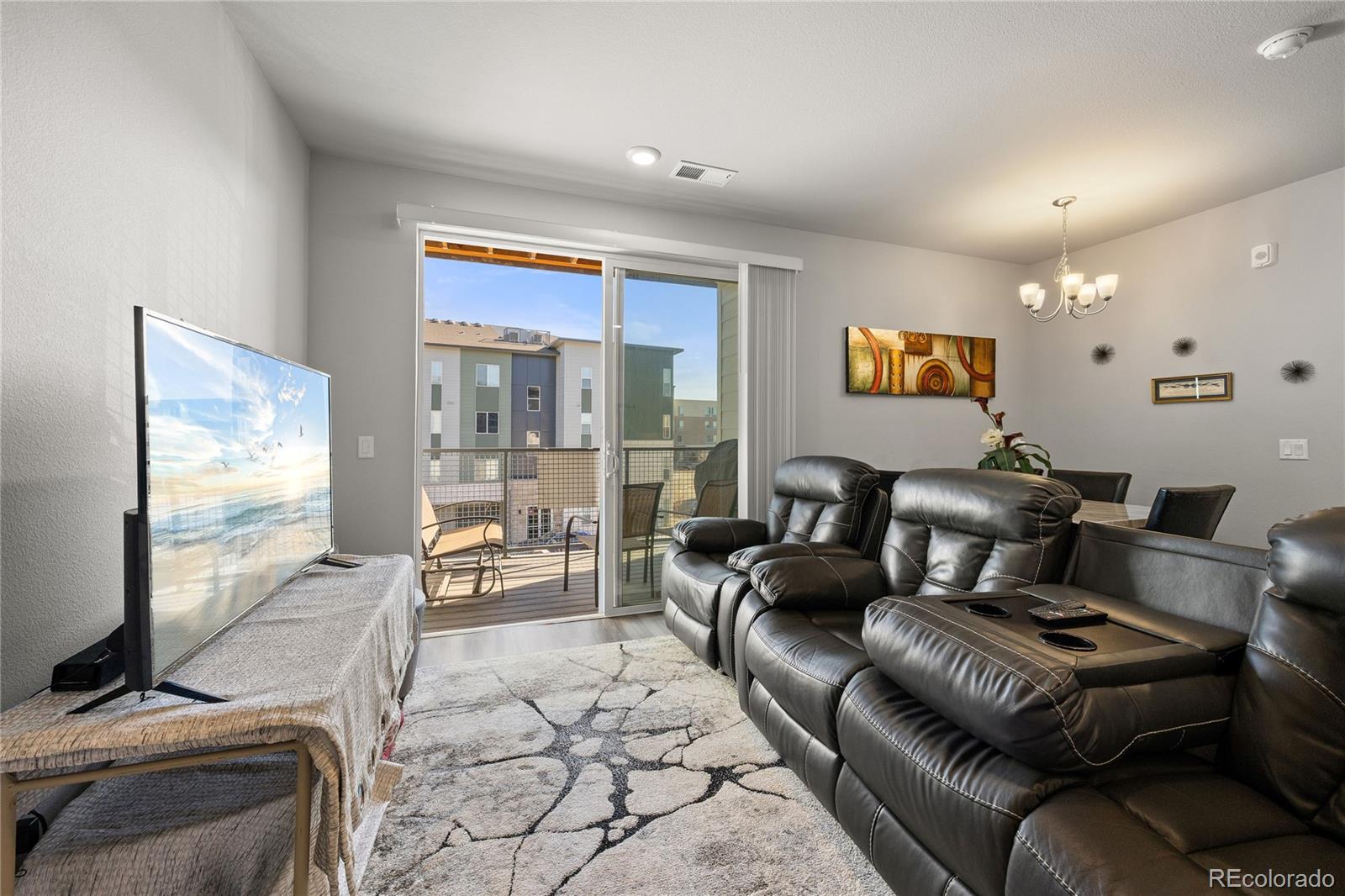9291 Twenty Mile Road, Unit 303 Parker, CO 80134 - Photo 5 of 28 a living room with furniture and a flat screen tv