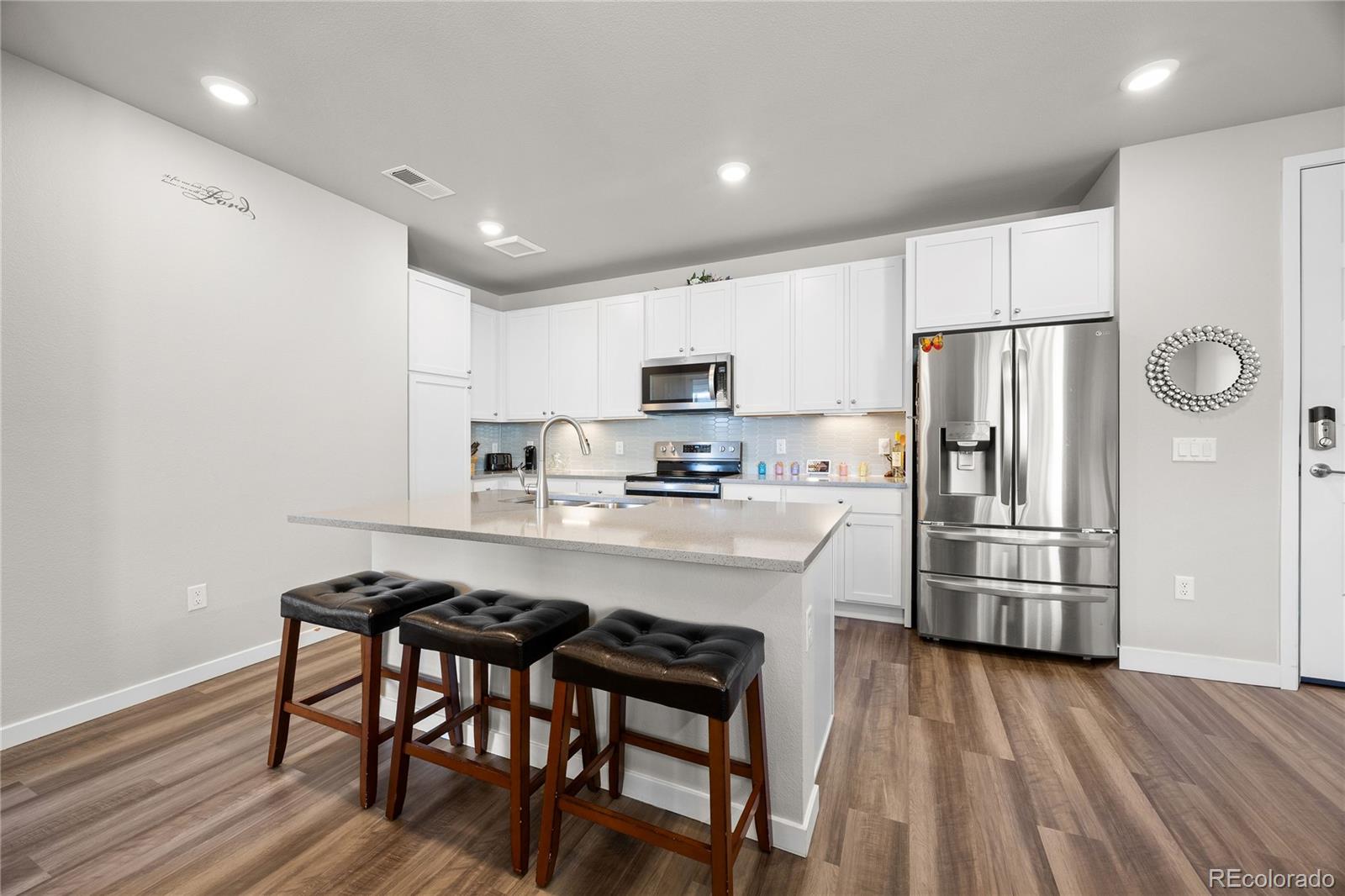 9291 Twenty Mile Road, Unit 303 Parker, CO 80134 - Photo 6 of 28 a kitchen with granite countertop a refrigerator stove microwave and cabinets