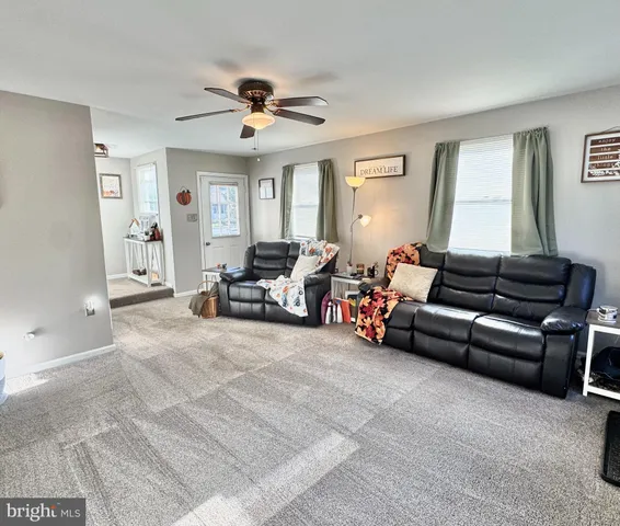 a living room with furniture and ceiling fan