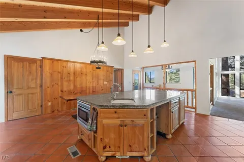 a kitchen with stainless steel appliances granite countertop a sink a stove and a wooden floors