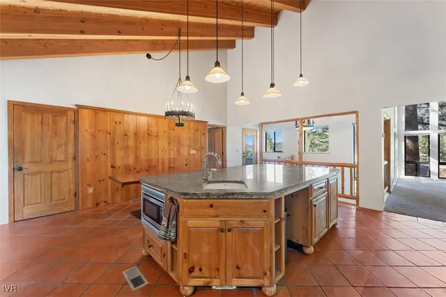 a kitchen with stainless steel appliances granite countertop a sink a stove and a wooden floors