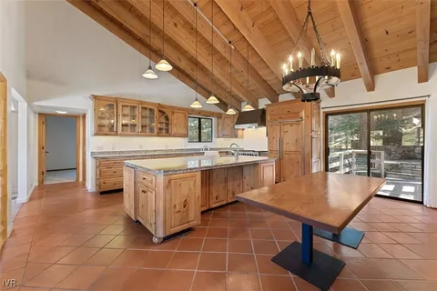 a kitchen with a stove a counter space a sink dishwasher a dining table and chairs with wooden floor