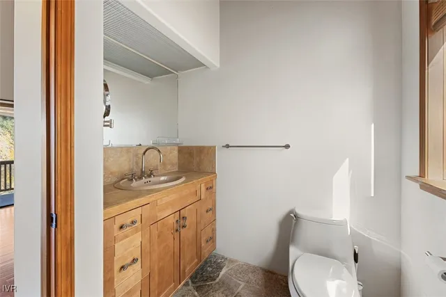 a bathroom with a granite countertop toilet sink and mirror