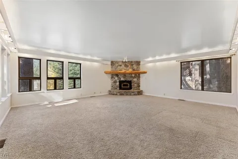 a view of an empty room with furniture and a window