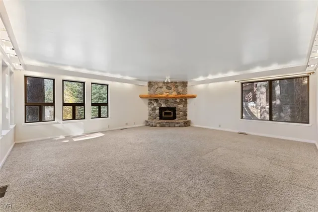 a view of an empty room with furniture and a window